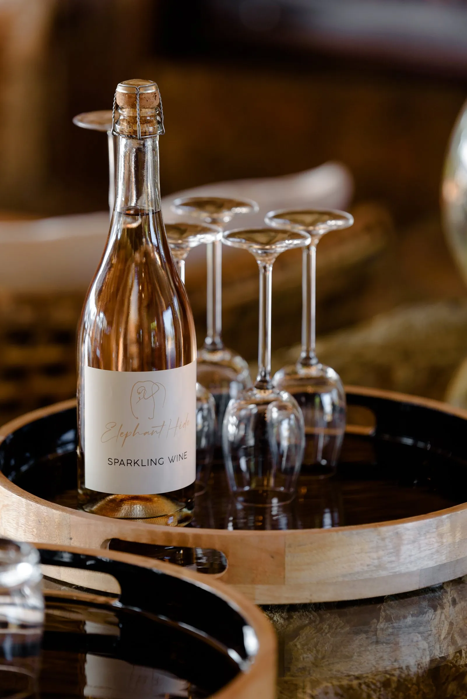 A bottle of Cape sparkling wine on a tray with glasses