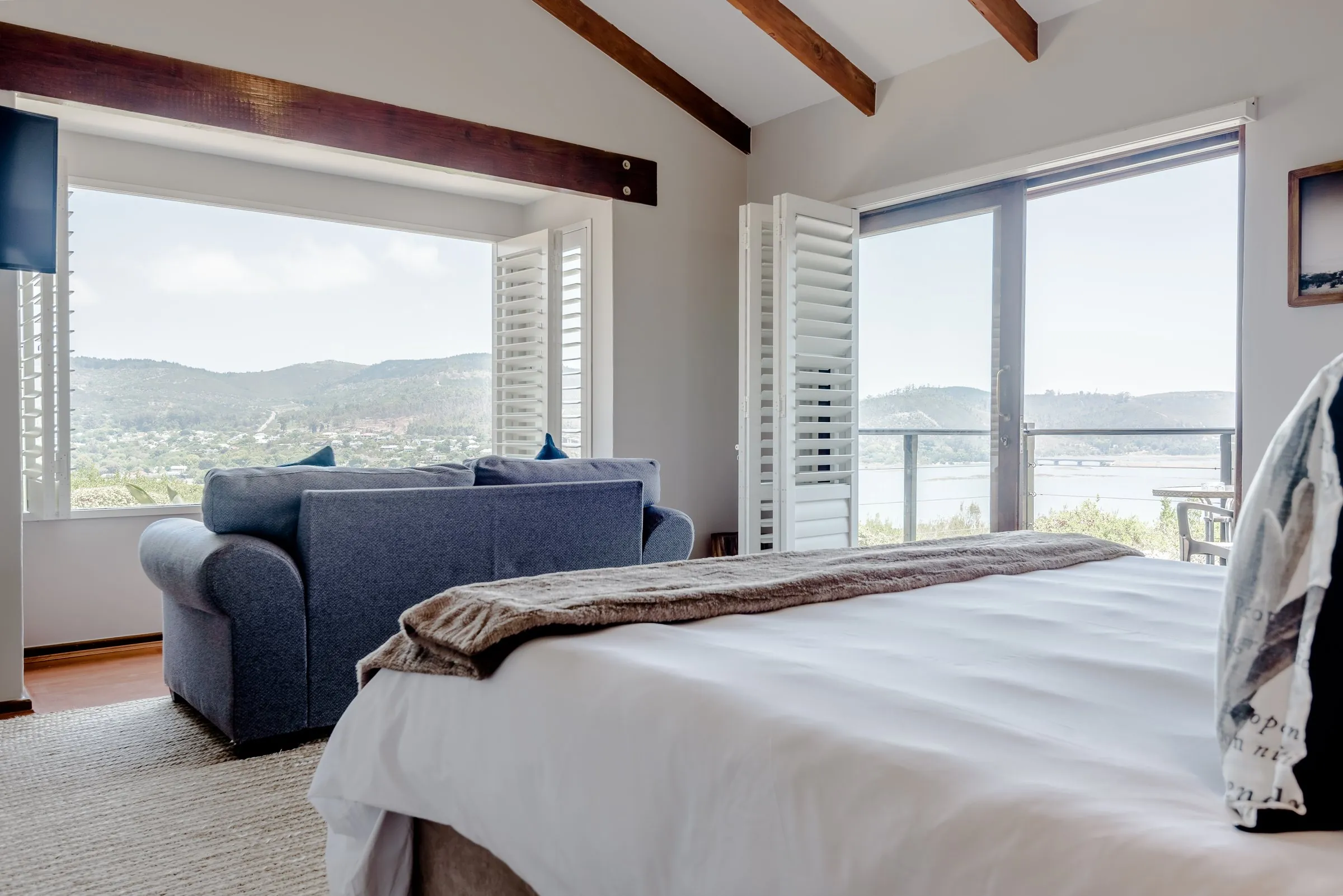 Lagoon Suite bedroom with a lounge corner and windows over the lagoon