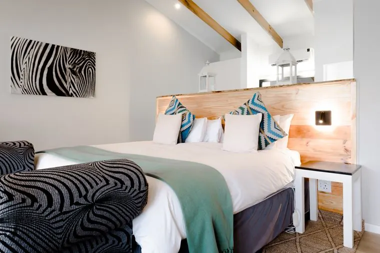 The bed with its timber headboard and zebra-print bench
