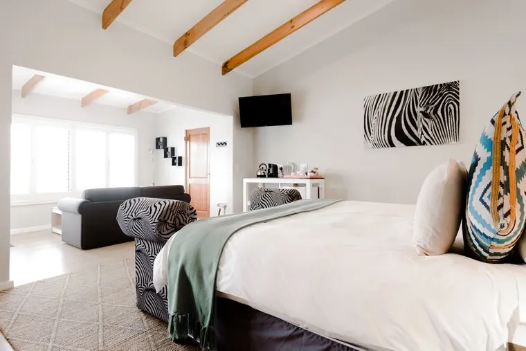 The bed beneath a zebra-print canvas