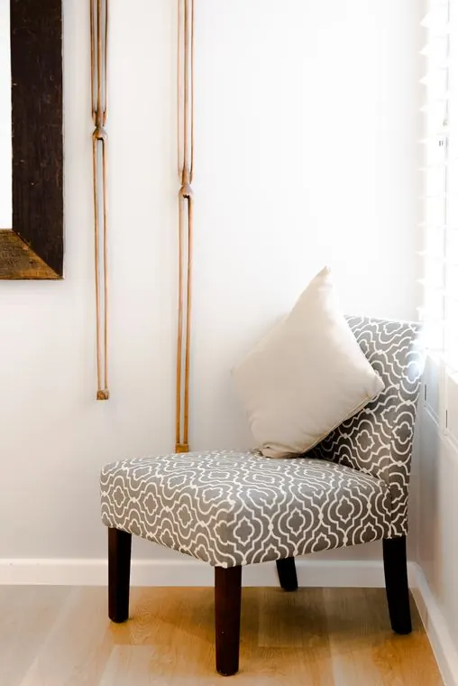 A patterned chair by the window