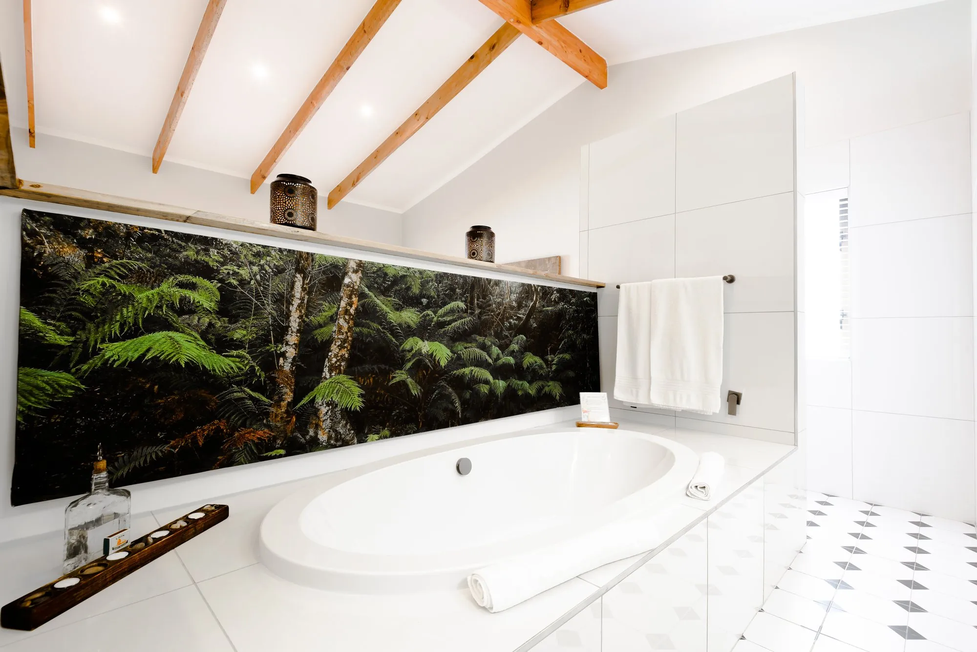 The bath against a forest mural, beneath a window