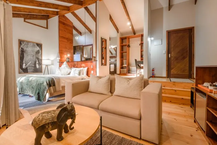 The lounge, with a carved elephant on the table and the bed beyond