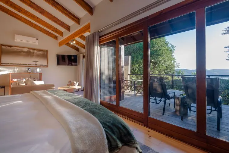 The bed beside glass doors to the deck and the lagoon