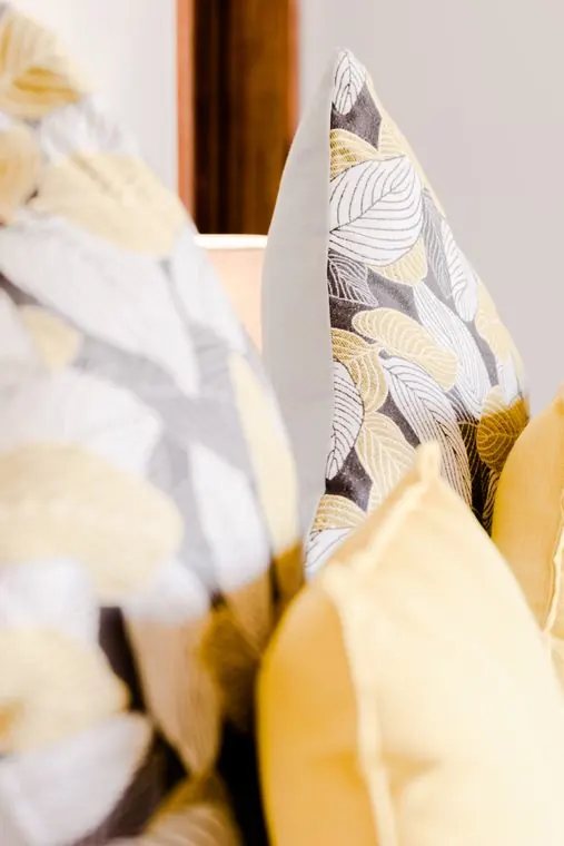 Yellow and patterned cushions on the bed