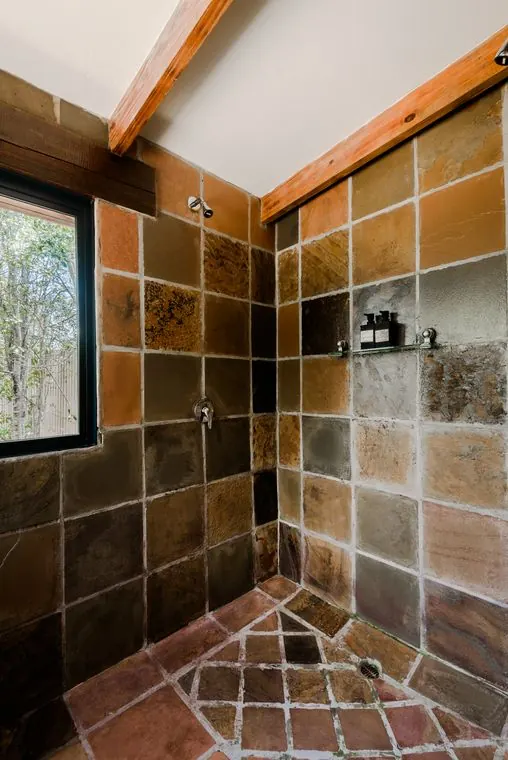 Walk-in twin shower in stone tiles