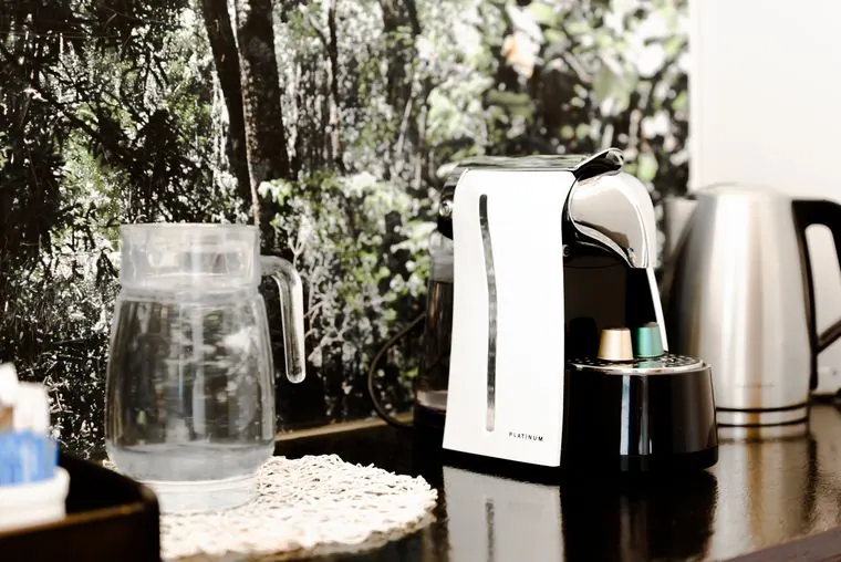 Coffee machine, kettle and water jug, with a forest print behind