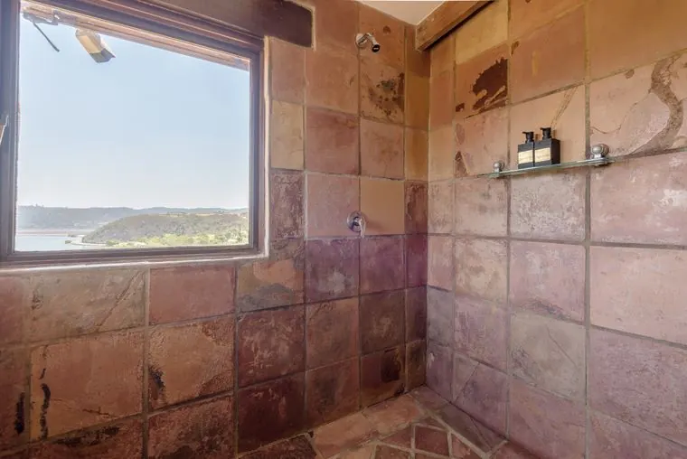 Twin shower in stone tiles, with a window to the lagoon