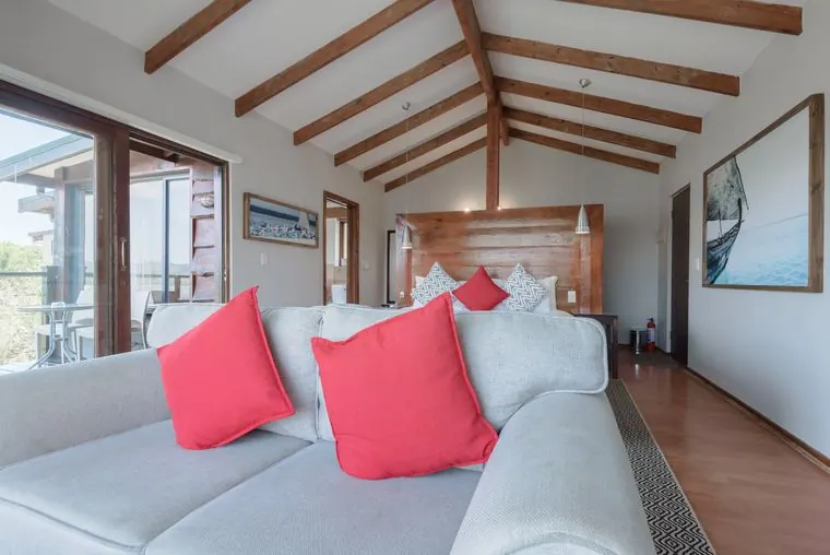 The sofa and its red cushions, with the bed behind