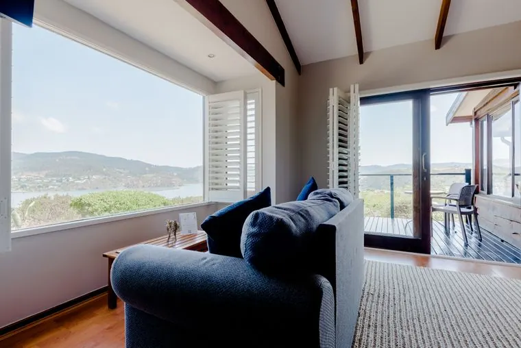 A sofa by the window and the door to the deck